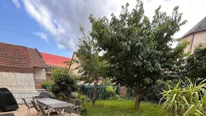 An outdoor patio with two lounge chairs, a table, and a barbecue grill. - Villa with indoor pool (Holtzheim)