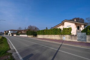 Eine Wohnstraße mit Häusern, blauem Himmel und befestigter Straße.