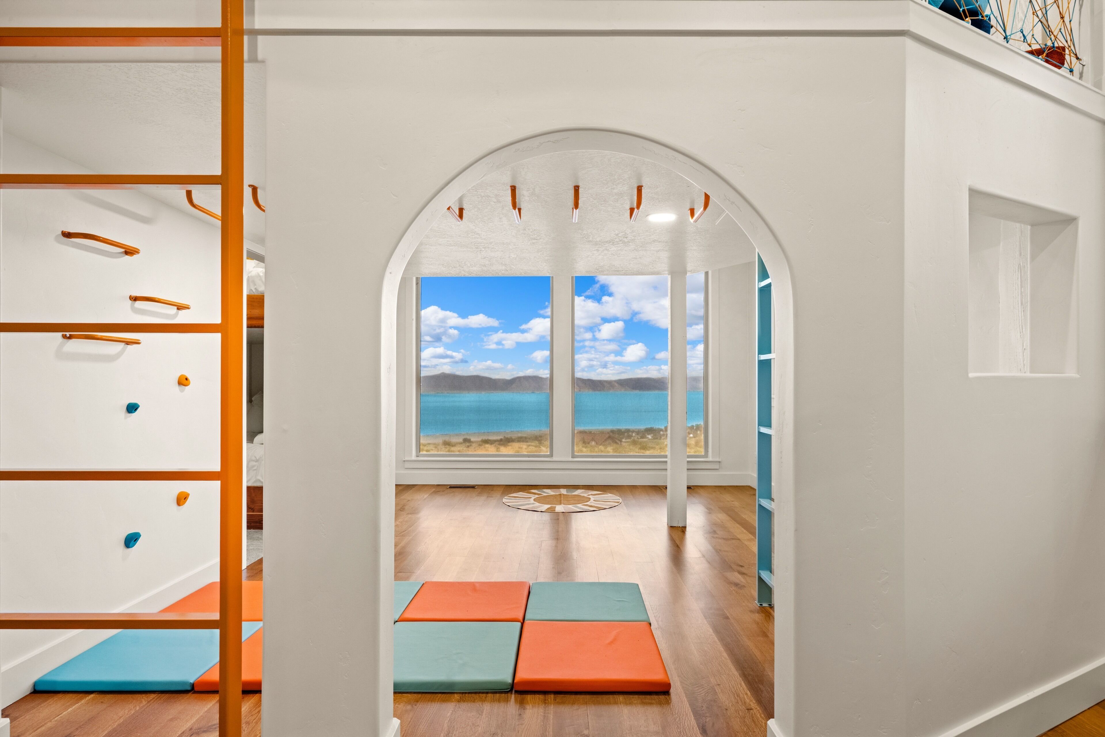 A children's playroom with a view of a beach through a large window.