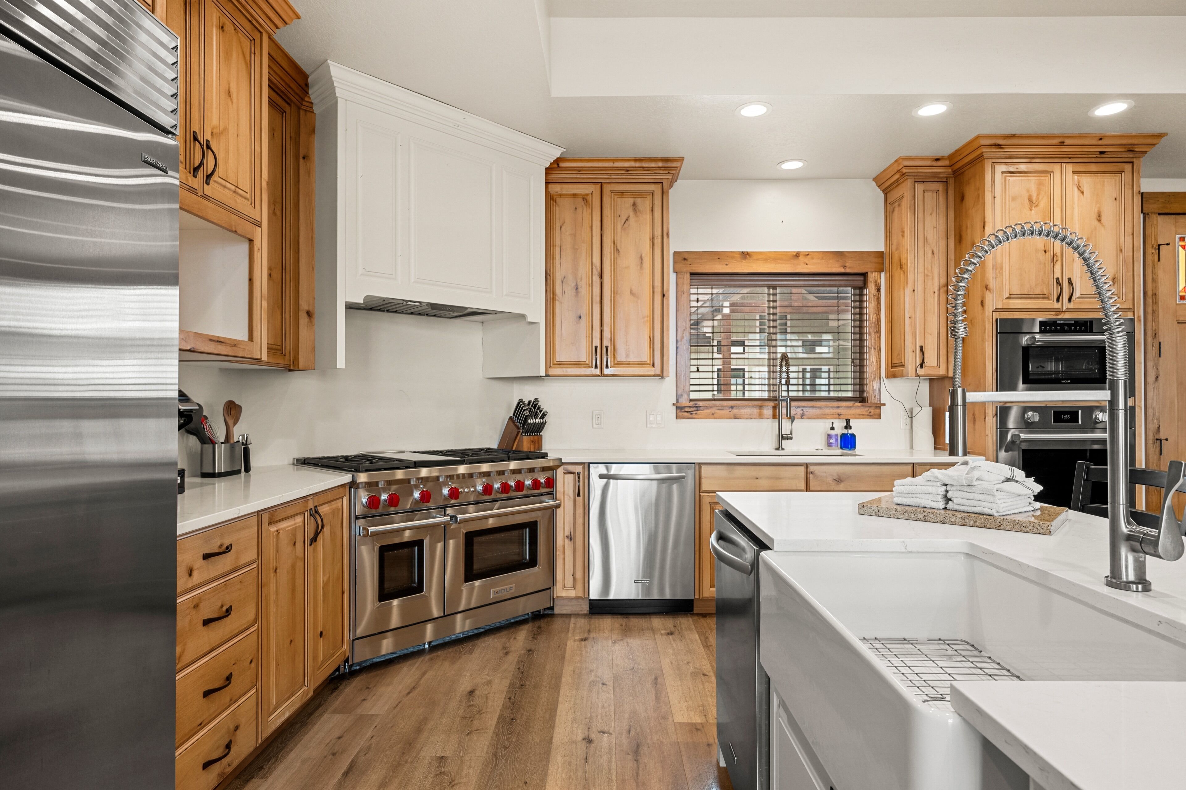 A modern kitchen with wooden cabinets, stainless steel appliances, and a built-in oven.
