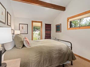 A bedroom with a bed, a bedside table, a lamp, a window, and a door leading outside. - Thulite Chalet - 20-ncd0315 2 Bedroom Home (Estes Park)