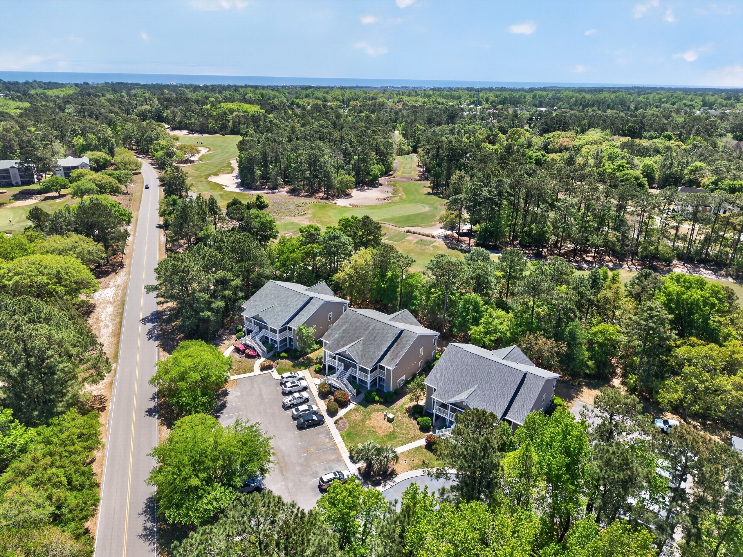 A residential area with houses, a golf course, and a road.