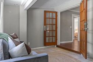 Ein Flur mit grauer Wand, einer Holztür und einem Teppichboden.