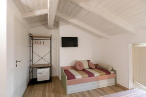A bedroom with a bunk bed, a desk, a chair, a TV, and a wardrobe. - IL GIARDINO SEGRETO (Castelfidardo)