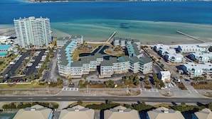 A coastal hotel complex with multiple buildings, a parking lot, and a beach view. - ☀️🩴Stunning Sound Front Views | Community Pool | Walk to Beach | Baywatch E5 (Pensacola Beach)