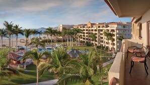 Un complexe hôtelier doté d’une piscine, de palmiers et offrant une vue sur l’océan.