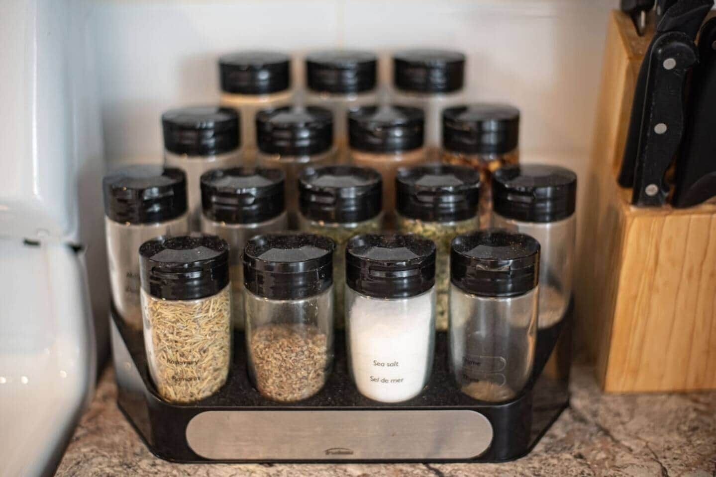 A spice rack with various containers holding different spices.