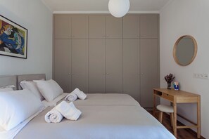 A bedroom with a bed, a wooden desk, a mirror, and a wardrobe. - Heart of Athens Hidden Gem - Elegant 2 Bed Flat (Athina)