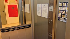 Ein Fahrinnenraum mit einer roten Notfalltür, einem Feueralarm und Informationsplakaten.