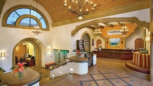 A spacious lobby with a reception desk, a chandelier, and a view of the outside. - San Jose del Cabo | Family Beach Retreat | Pool + Beach | 2BR (San Jose del Cabo)