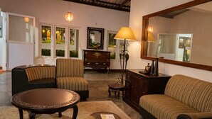 A living room with a sofa, armchair, coffee table, and a fireplace. - Habarana Inn - Offiacl (Habarana)