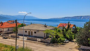 A coastal residential area with houses, a clear sky, and a view of the sea. - Cozy apartment for 2 people in Novi Vinodolski with balcony and barbecue (Novi Vinodolski)