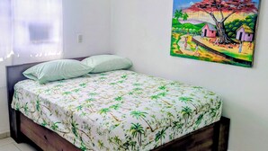 Une chambre à coucher avec un lit, un tableau, une fenêtre avec des rideaux et un luminaire fixé au mur.