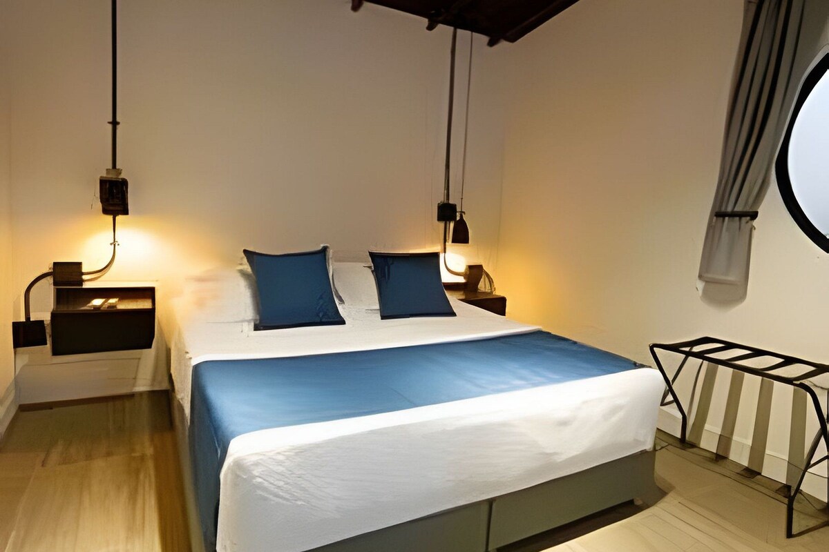 A bedroom with a bed, bedside tables, a window, and a ceiling fan.