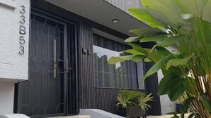 A modern building with a black door, a staircase, and a large plant. - Bluelux Med - B&B (Medellín)