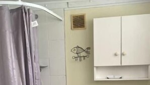 A bathroom with a shower, toilet, and a cabinet. - Room-tranquil Browns Bay Guest Rooms wit (Auckland)