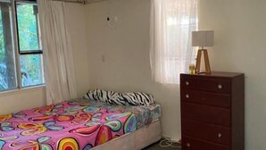 A bedroom with a bed, a dresser, a window, and a lamp. - Room-tranquil Browns Bay Guest Rooms wit (Auckland)