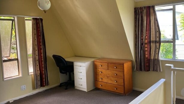 A bedroom with a desk, dresser, and a window with curtains. - Room-tranquil Browns Bay Guest Rooms wit (Auckland)