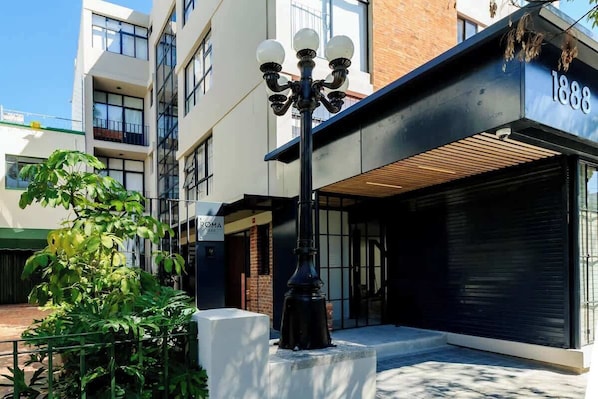 Un edificio moderno con un toldo negro, una farola y un cartel con el número 1888.