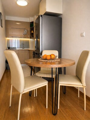 A compact kitchen with a dining area featuring a round table and two chairs.