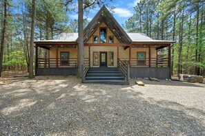 Un chalet doté d’un toit à forte pente, d’une façade en bois et d’un escalier extérieur menant à la porte d’entrée.