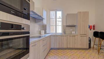 A modern kitchen with built-in ovens, a window, and a patterned floor.