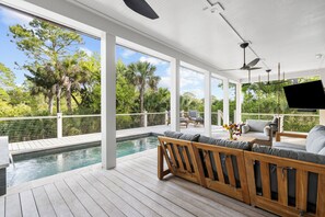 A covered outdoor area with a pool, wooden deck, and seating. - Spectacular new rental home close to Ocean Course (Kiawah Island)