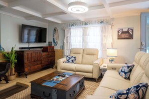 Ein Wohnzimmer mit einer Couch, einem Couchtisch, einem Fernseher und einem Holzschrank.