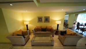 A living room with a sofa set, a coffee table, and two lamps.