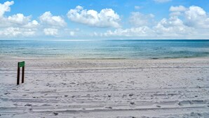 Une plage avec un panneau indiquant la prĂ©sence dâun hĂŽtel.