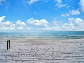 Ein Strand mit einem Schild, das ein Hotel anzeigt.