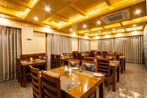 A conference room with wooden tables and chairs, arranged for meetings. - Kavin Suryansh Regency - Near Mall Road (Manali)
