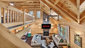 Un interno in legno con un camino, un cartello Netflix e una zona mansardata.