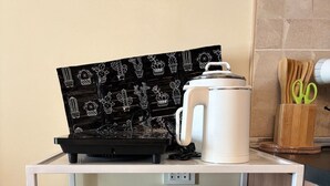 A kitchen with a microwave, a coffee maker, and a tray with a cactus pattern. - Modern Comfort at Avida Towers Riala (Cebu City)