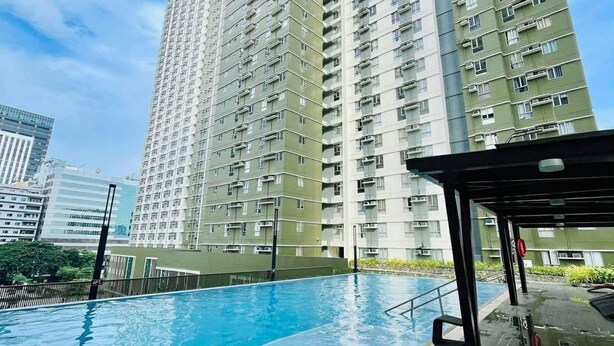 A high-rise residential building with a swimming pool in the foreground. - Modern Comfort at Avida Towers Riala (Cebu City)