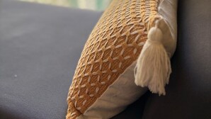 A room with a window, a cushion with a tassel, and a wall socket. - Modern Comfort at Avida Towers Riala (Cebu City)