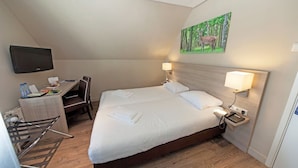 A hotel room with a bed, desk, chair, TV, and a painting on the wall. - From Adventure Parks to Art Museums—Stay Near It All! Terrace, Onsite Dining! (Beekbergen)