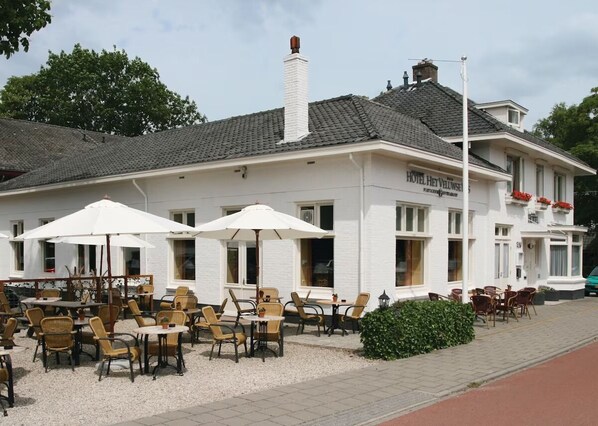 A hotel with outdoor seating, a white facade, and a chimney. - Relax in Comfort Close to Dutch Palaces and Woodland Trails! Onsite Dining! (Beekbergen)