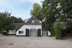 Een gebouw met het bord 'OP DE EELE' en een grindpad.