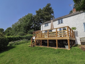 A white building with a wooden deck, a chimney, and a satellite dish. - 2 Oak Tree Cottages (Axminster)