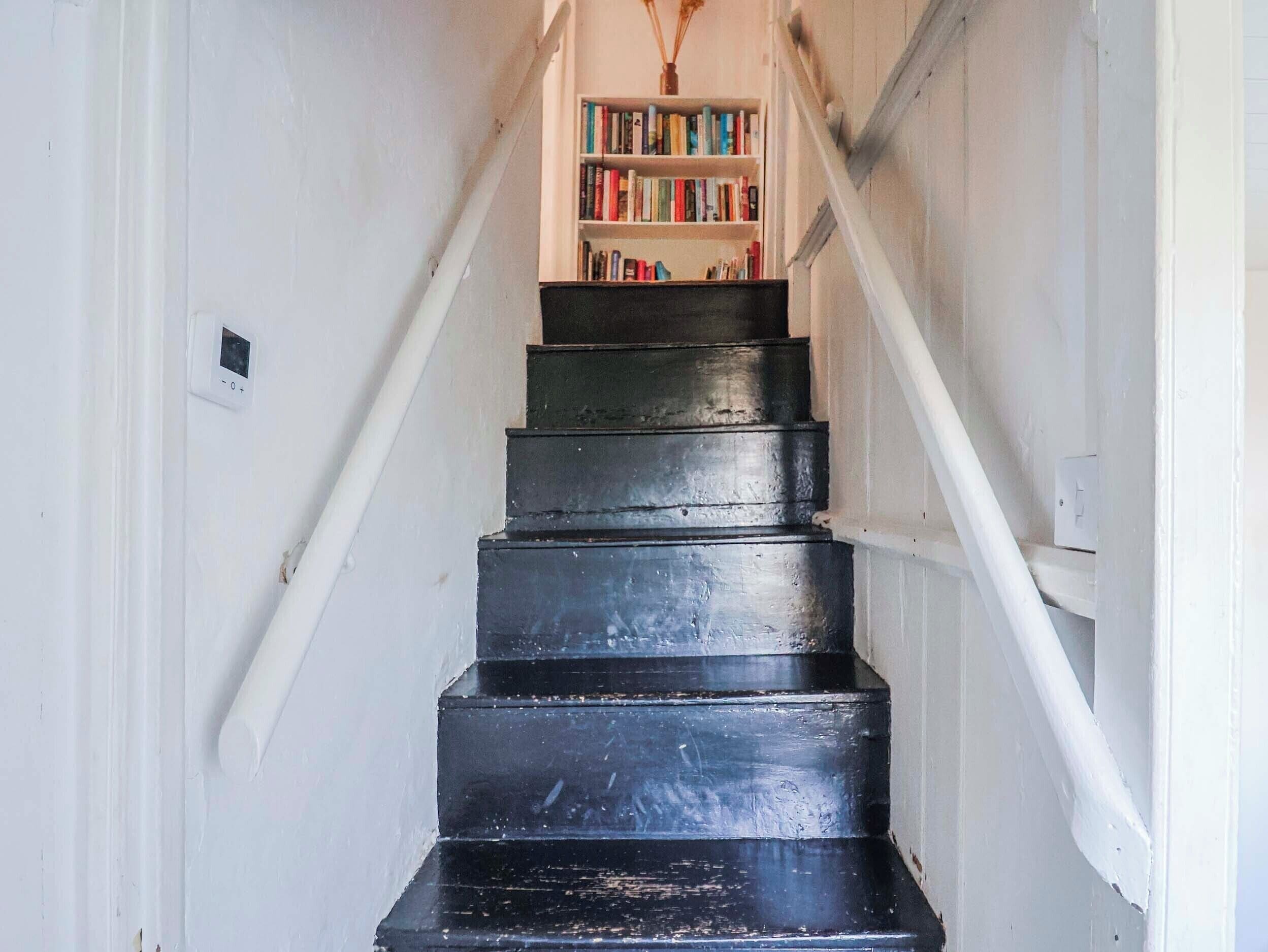 Un escalier menant à une bibliothèque remplie de livres.