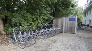 Une rangée de vélos est garée devant un bâtiment sur lequel est apposée une pancarte indiquant « Garage à vélos ».