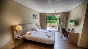 Une chambre d’hôtel avec un lit, des tables de chevet, un bureau et une chaise.