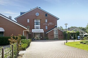 Un hotel con fachada de ladrillo, un cartel que dice 'HOTEL HEIDEHOF' y una entrada pavimentada.
