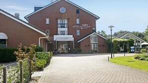 Hotelli, jonka julkisivu on tehty tiilestä, ja jonka yläpuolella on kyltti, jossa lukee »HOTEL HEIDEHOF», sekä asfaltoitu sisäänkäyntialue.