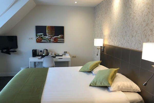 Recharge in a calm room with bedside lighting and workspace.