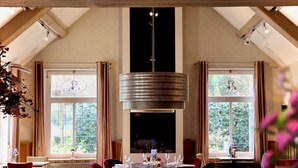 A dining area with a round table, chairs, and a hanging light fixture. - Unwind in Zeist with On-site Pool, Dining, Free Parking, and a Peaceful Ambiance (Zeist)