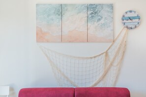 A room with a hammock, a red couch, and a wall-mounted clock. - Affittimoderni Valledoria - La Duna Bianca (Valledoria)