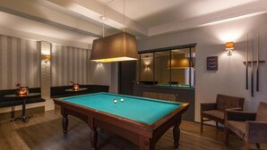 A pool table with a hanging light fixture, a billiards rack, and a seating area with chairs. - Modern Room Perfect for Family Nature Trips Near Speelbos Nijverdal (Hellendoorn)