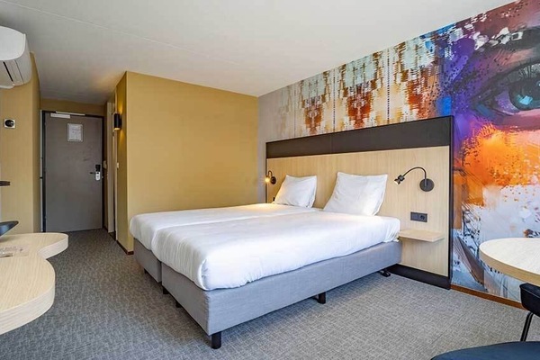 Recharge in a sleek room with crisp linens and warm lighting.